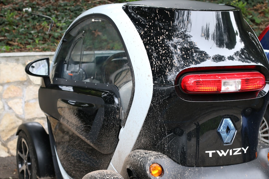 a smart car parked next to a stone wall